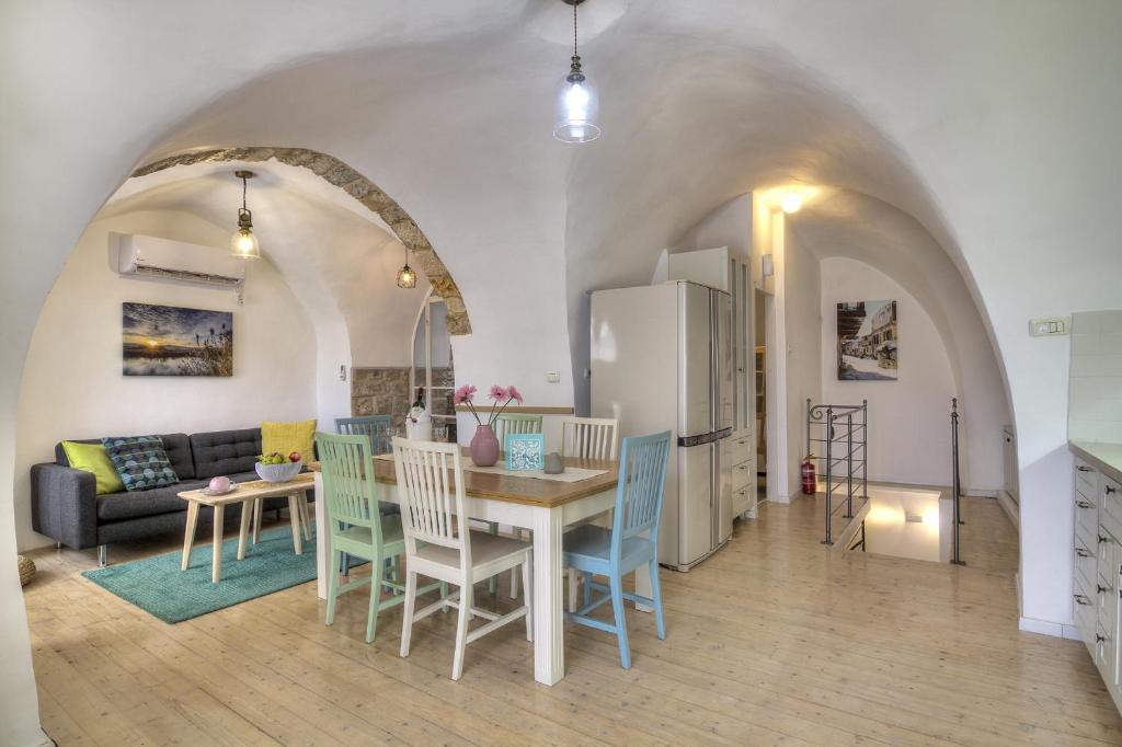 a kitchen and living room with a table and chairs at Rashbi 54 in Safed