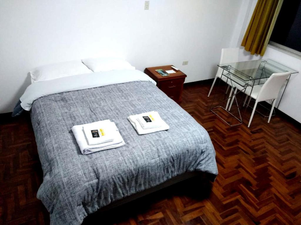 a bedroom with a bed with two towels on it at Santa Victoria House in Chiclayo