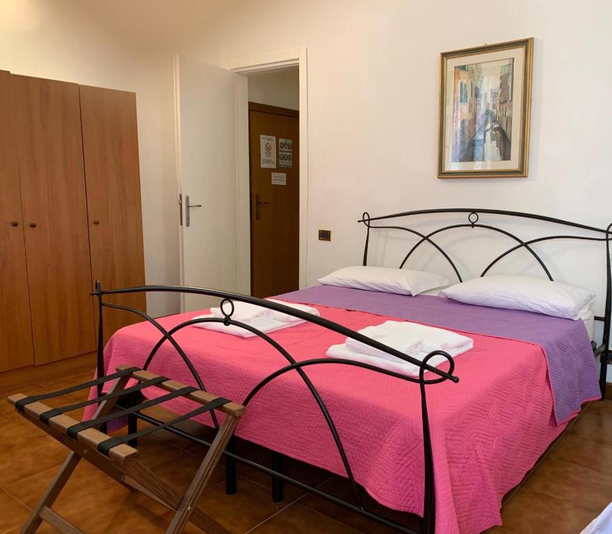 a bedroom with a bed with a pink blanket at Rialto House wi-fi in Venice