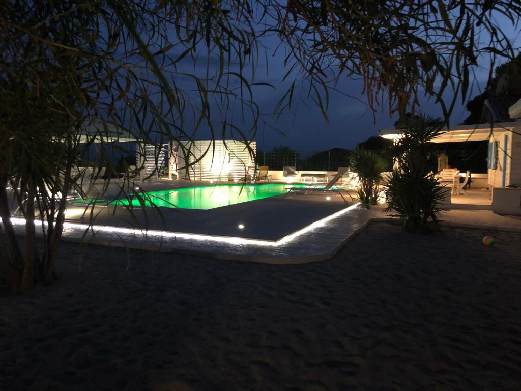 GIGLIO DI MARE Residence في سيليا مارينا: اضاءه المسبح ليلا مع الاضائه