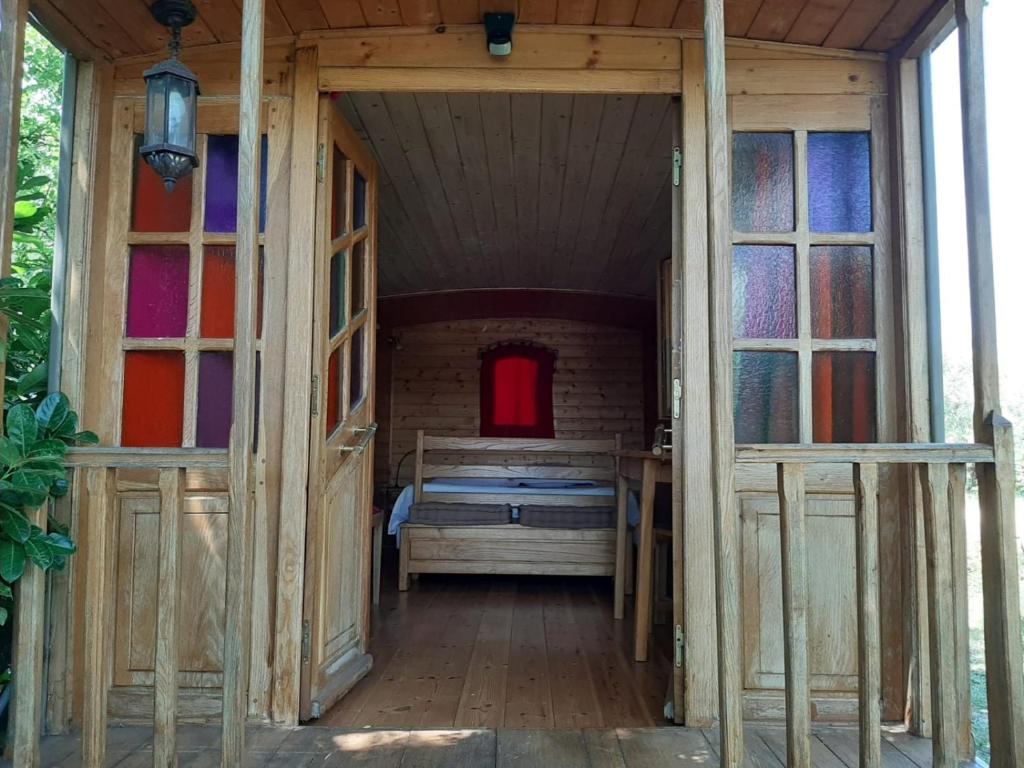 Roulotte Marcel Chaix Accueil في Étoile-sur-Rhône: غرفة صغيرة بسرير في منزل خشبي