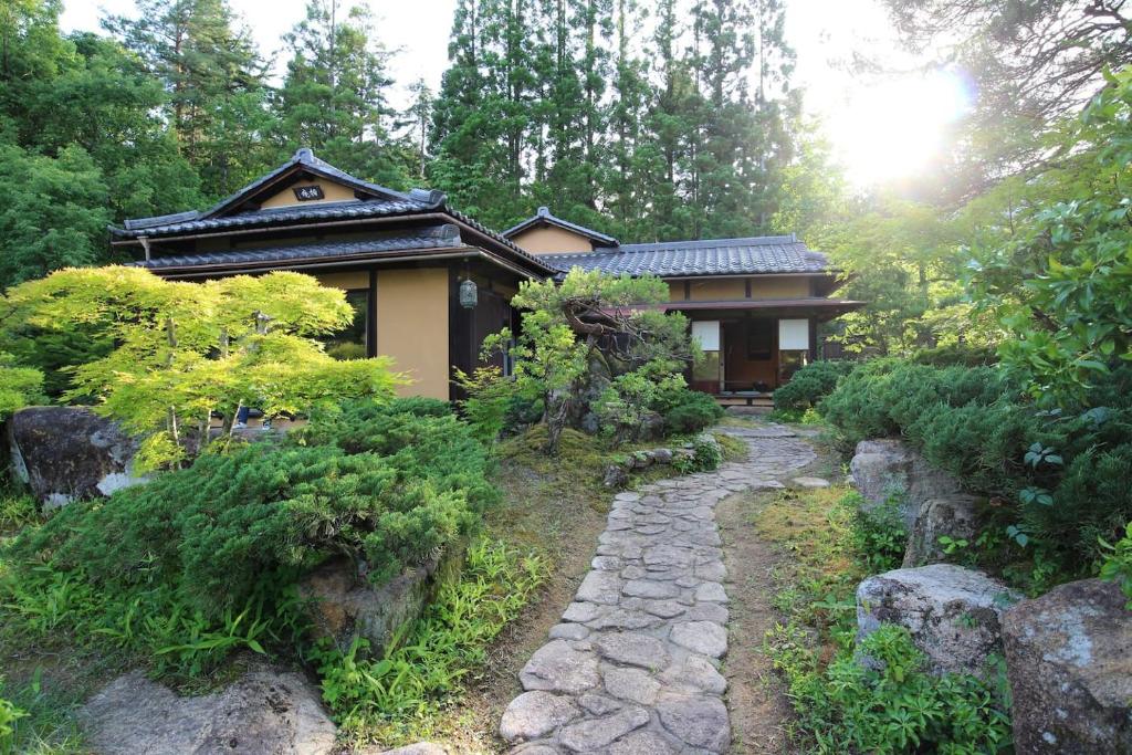 uma casa com um caminho de pedra em frente em Shohakuen em Takayama