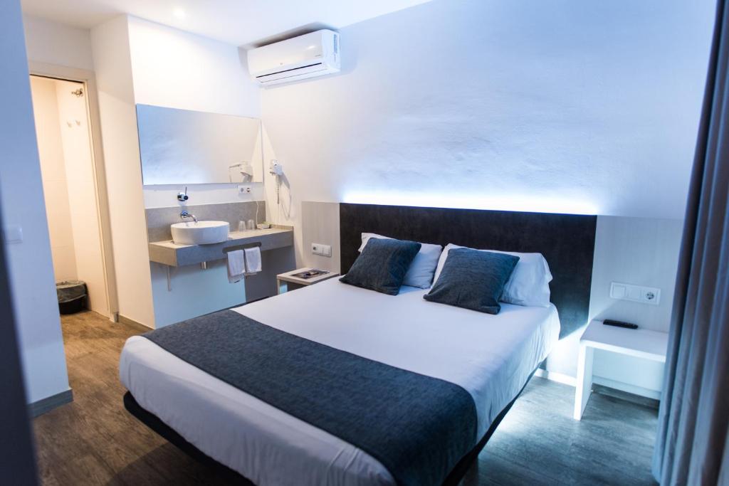 Habitación de hotel con cama y lavabo en Hostal Ribas, en Lloret de Mar