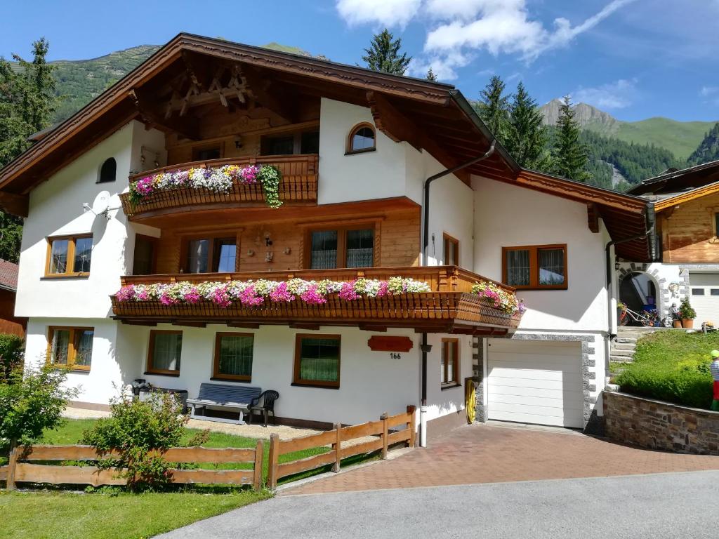 ein Haus mit Blumen auf dem Balkon in der Unterkunft Ferienwohnung Bergblick in Schmirn