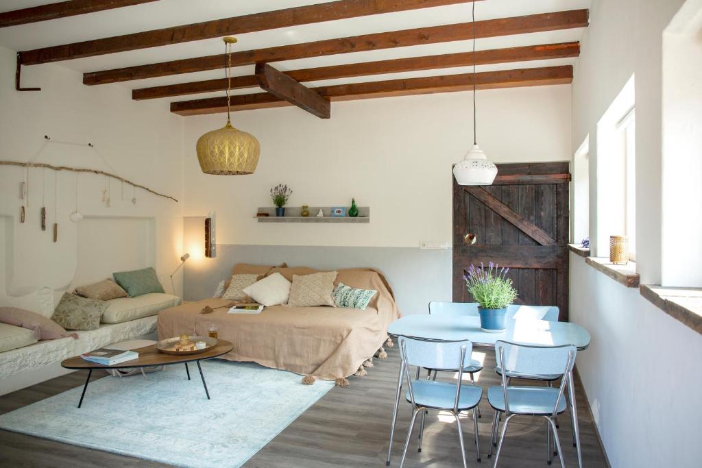 sala de estar con cama, mesa y sillas en Lavender Lodge en Achthuizen