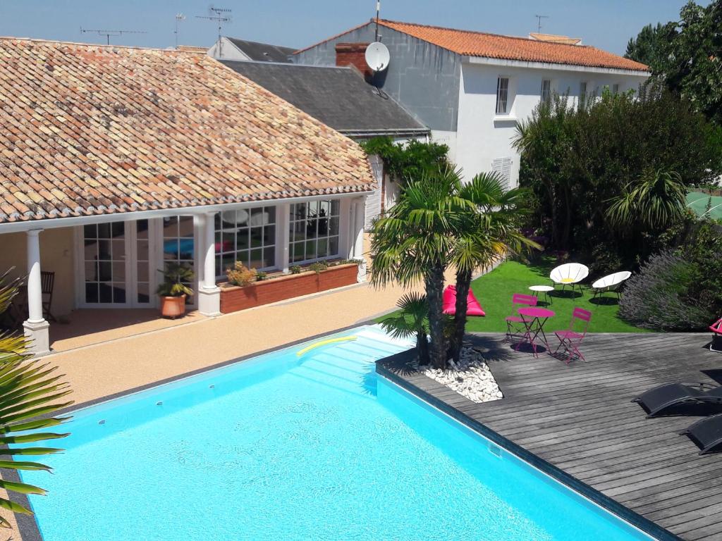 a swimming pool in front of a house at Le Manoir de l'antiquité in Challans