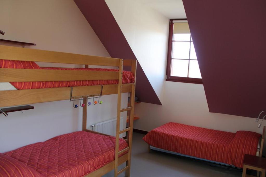a room with two bunk beds and a window at La Brise de Mer in Saint-Michel-Chef-Chef