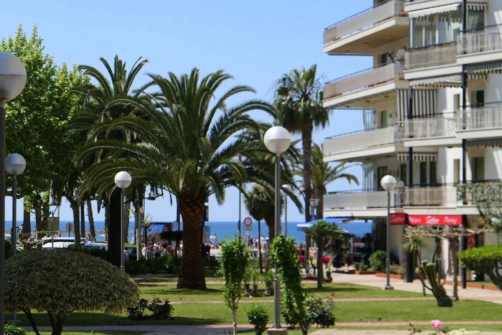 a resort with palm trees and a building at Rentalmar Delfos Playa in Salou
