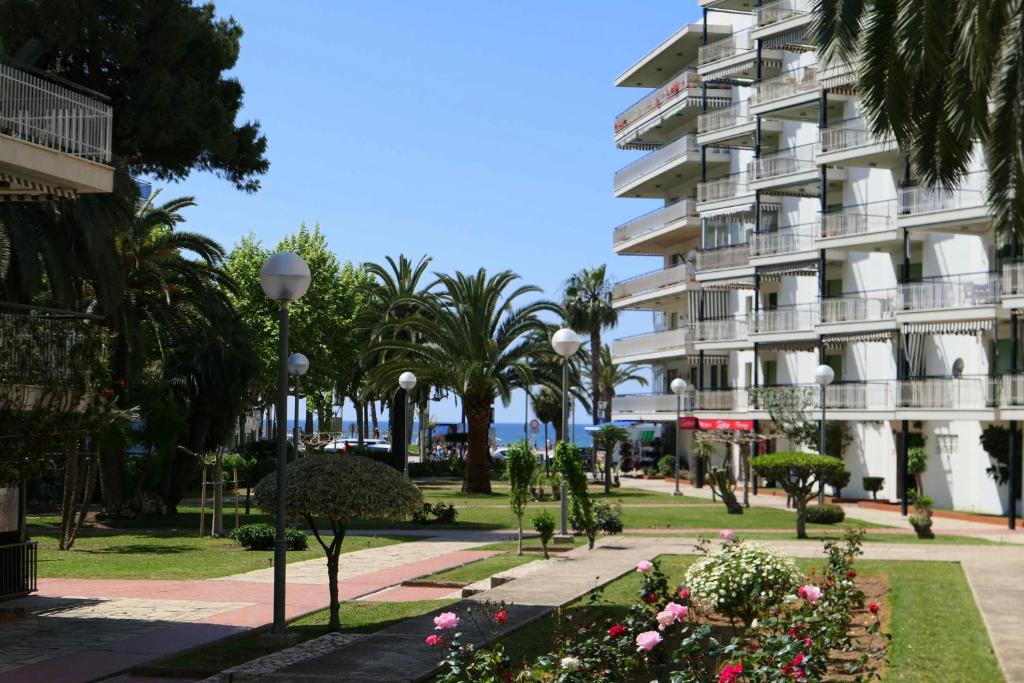 a park in front of a large building at Rentalmar Delfos Playa in Salou