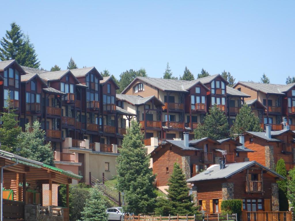 un grupo de casas en una colina con árboles en Les Eglantines studio non adapté aux personnes avec des difficultés physiques, en Bolquere Pyrenees 2000