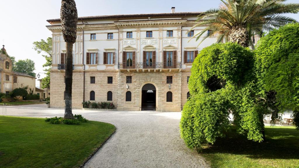 un grande edificio con un grande cespuglio di fronte di Villa Corallo a SantʼOmero