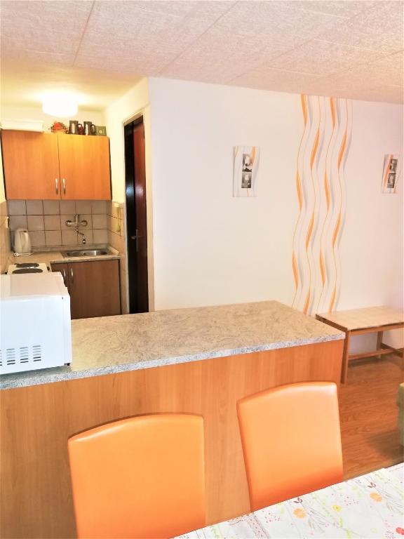kuchnia z pomarańczowymi krzesłami i blatem w obiekcie APARTMÁN BERAN w Rokitnicach nad Izerą