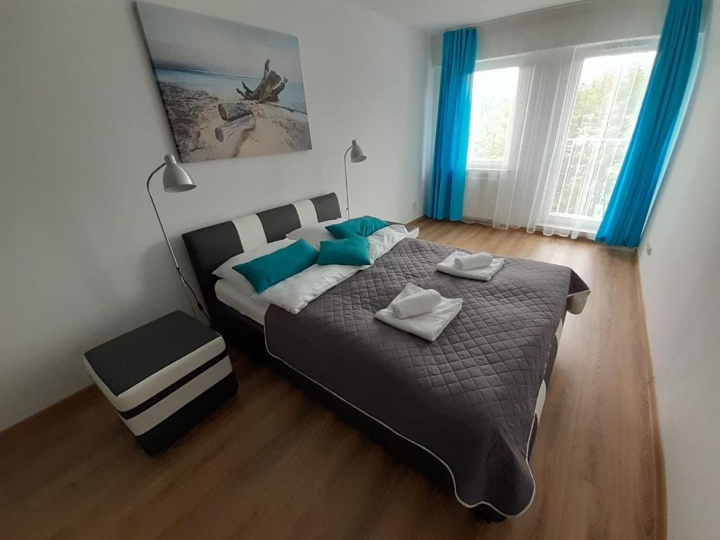 a bedroom with a large bed with blue curtains at Apartament Dmowskiego - Kępa Mieszczańska in Wrocław