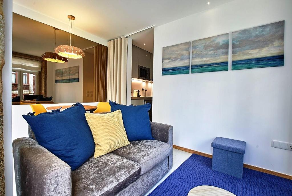 uma sala de estar com um sofá com almofadas azuis em Almar Apartments na Póvoa do Varzim