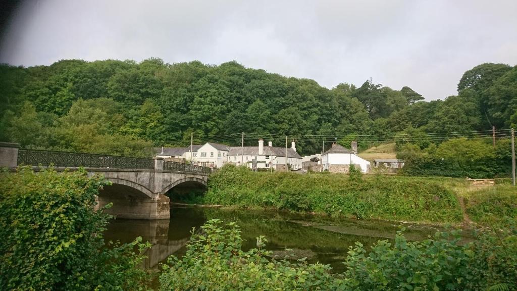 a bridge over a river with houses and trees at The Rising Sun in Umberleigh Bridge