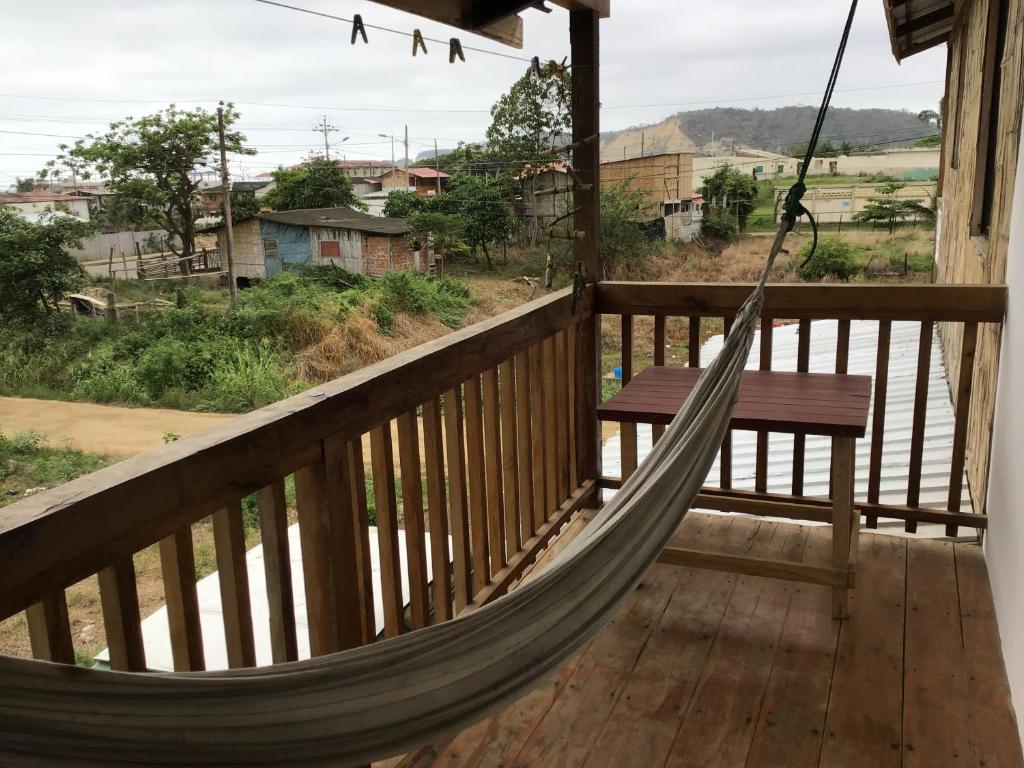 a hammock on a porch with a view at Suki Cafe Apartments in Canoa