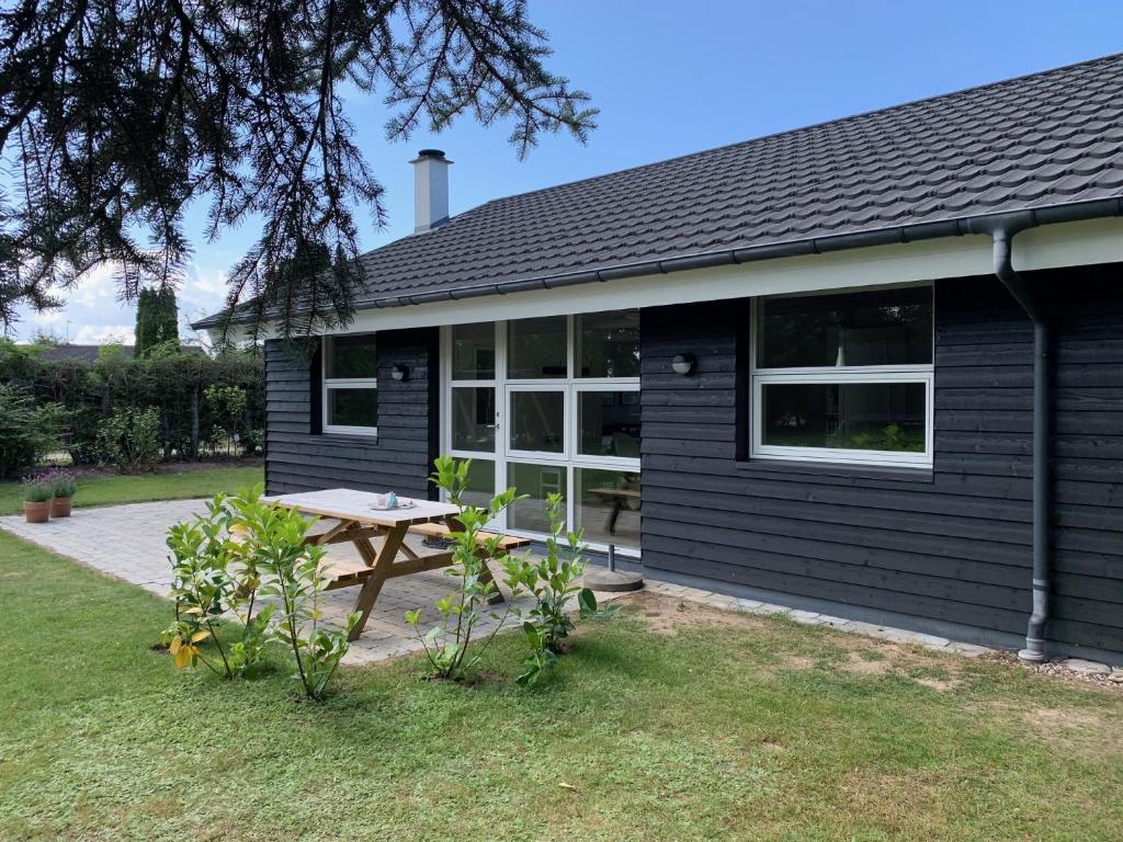a black house with a picnic table in front of it at Holiday home Als in Nordborg