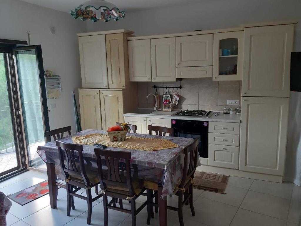 a kitchen with a table and chairs and a kitchen with white cabinets at Casa Ateleta LU.PA. in Ateleta