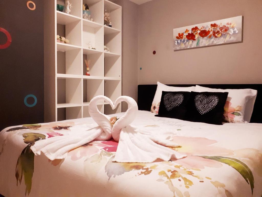 een slaapkamer met een bed met twee zwanen die een hart vormen bij Residentie Ruytingen in Oostende