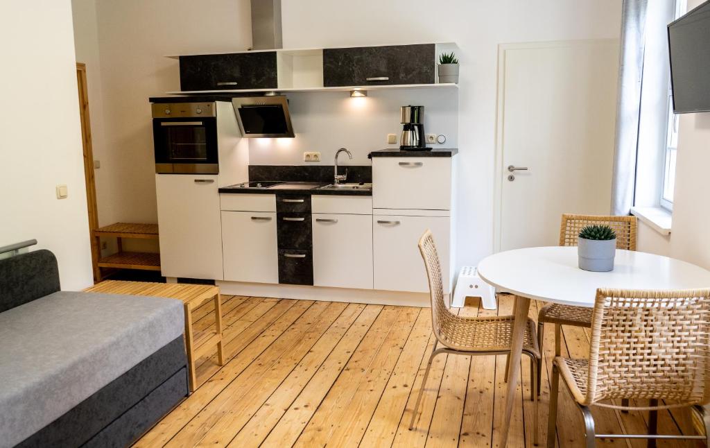 a kitchen and dining room with a table and chairs at Ferienwohnungen im Gasthaus Zur Grünen Wiese in Sebnitz