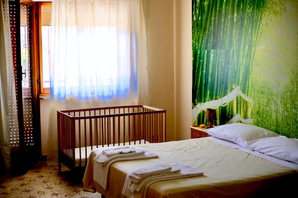 a bedroom with a bed with a green wall at LA CASA DELL'ORSO in Ciampino