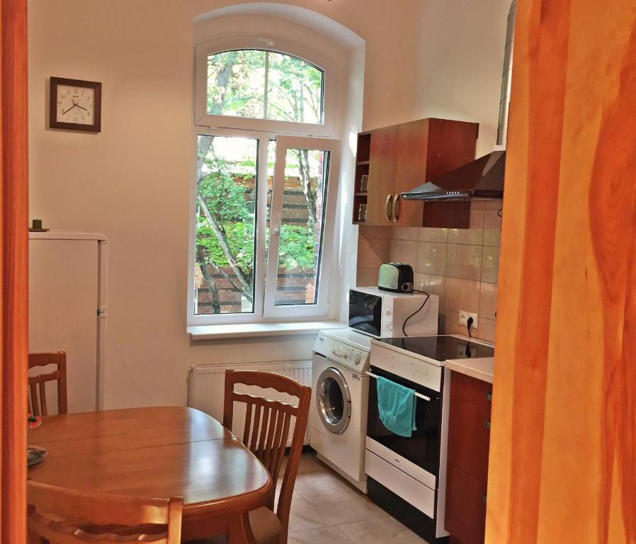 a kitchen with a table and a stove top oven at Apartment Under the Maple in Klaipėda