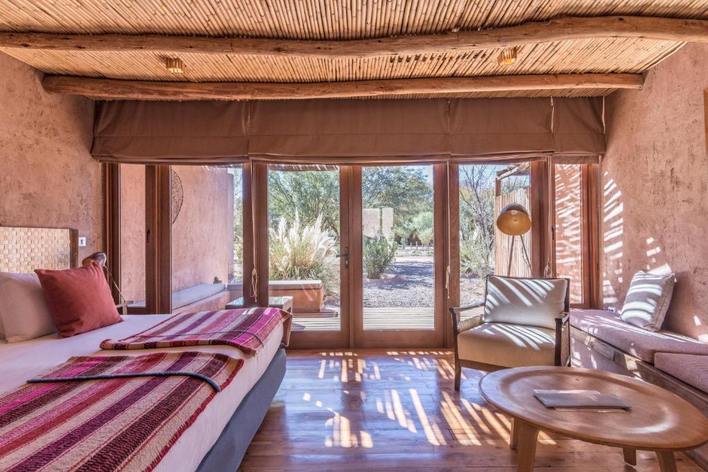 1 dormitorio con cama, sofá y mesa en Hotel Cumbres San Pedro de Atacama, en San Pedro de Atacama