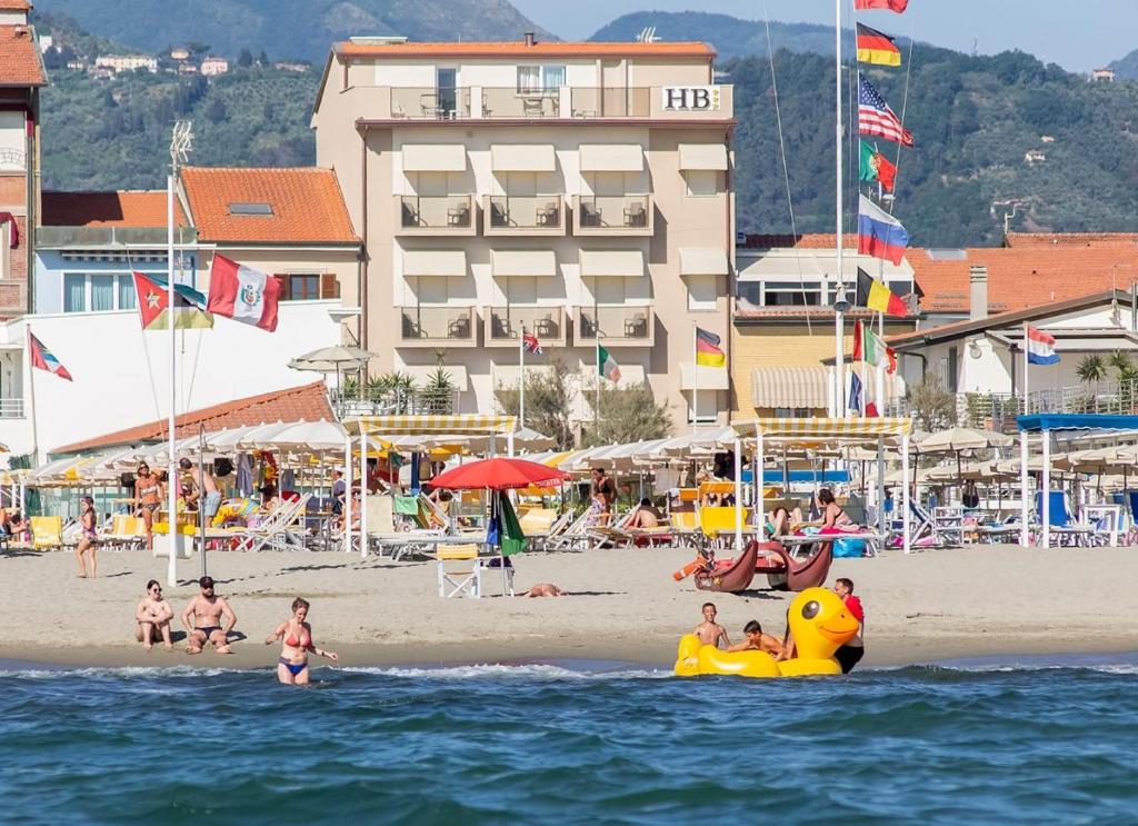 a group of people playing on a beach with an inflatable at Hotel Biagi & Residence in Lido di Camaiore