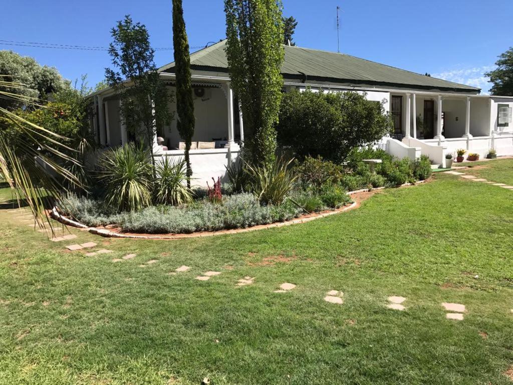 una casa con un jardín delante de ella en Karoo Ouberg Guest Lodge en Middelburg