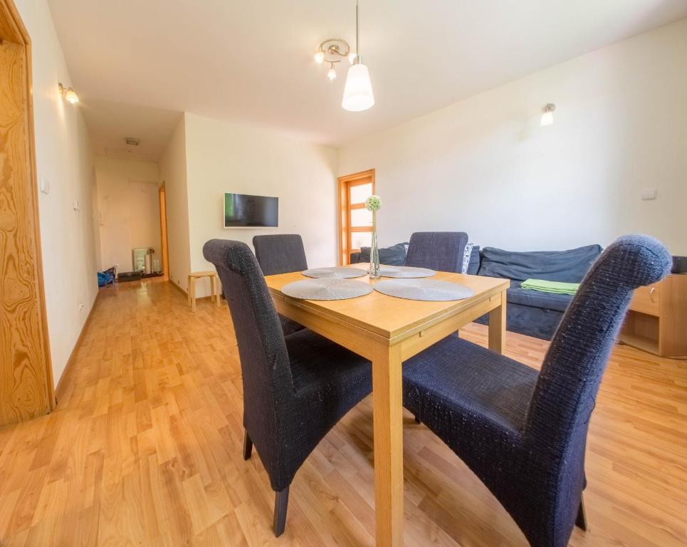 a dining room with a wooden table and chairs at Apartament Zdrojowy in Lądek-Zdrój