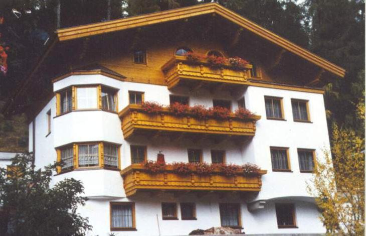 ein weißes Gebäude mit Balkonen und Blumen darauf in der Unterkunft Haus Anton Schranz in Sankt Anton am Arlberg