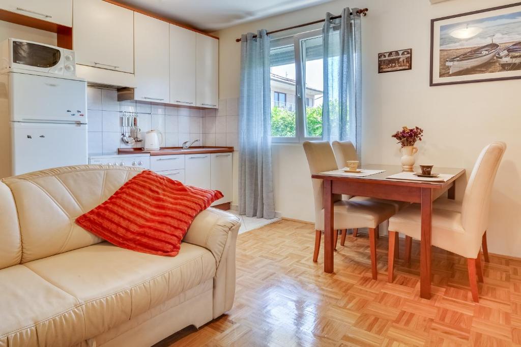 Apartment Sweet في زادار: غرفة معيشة مع أريكة وطاولة طعام