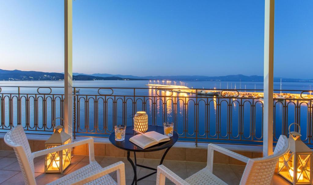 a balcony with a table with a book and chairs at Pantheon City Hotel in Gythio