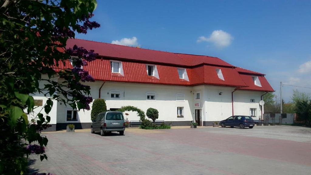 duży biały budynek z czerwonym dachem w obiekcie HOTEL FAHO w mieście Przemyśl