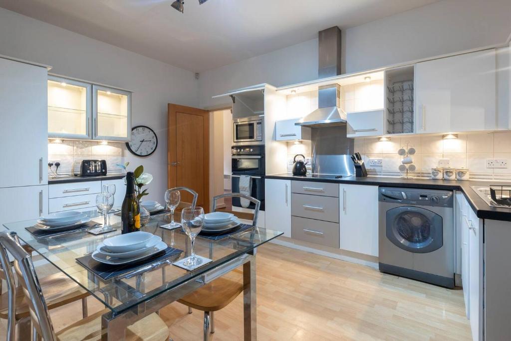 a kitchen with a glass table and a washer at Leicester Luxury Apartments - Princess in Leicester