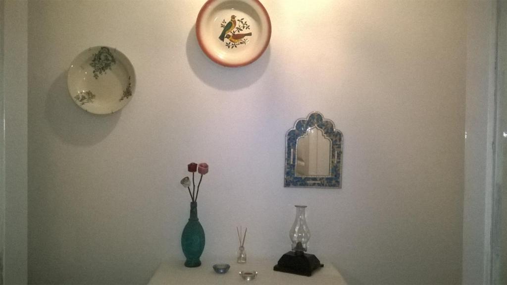 a shelf with vases and a mirror on a wall at The Aqueduct Guesthouse in Évora