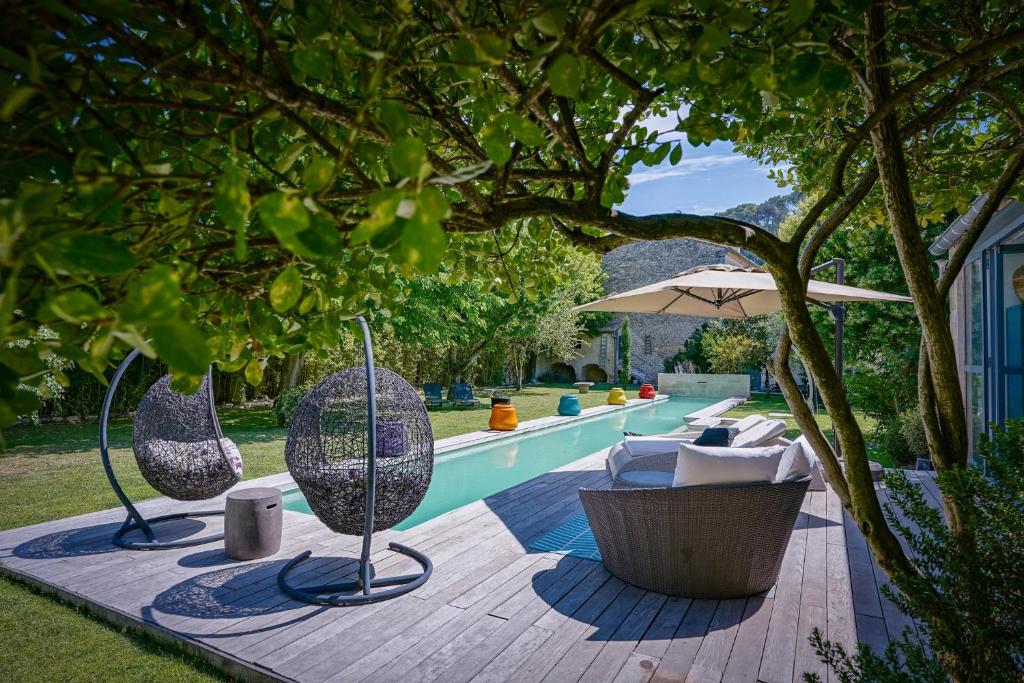 - une piscine avec 2 chaises et un parasol dans l'établissement Mas Bleu, à Sommières