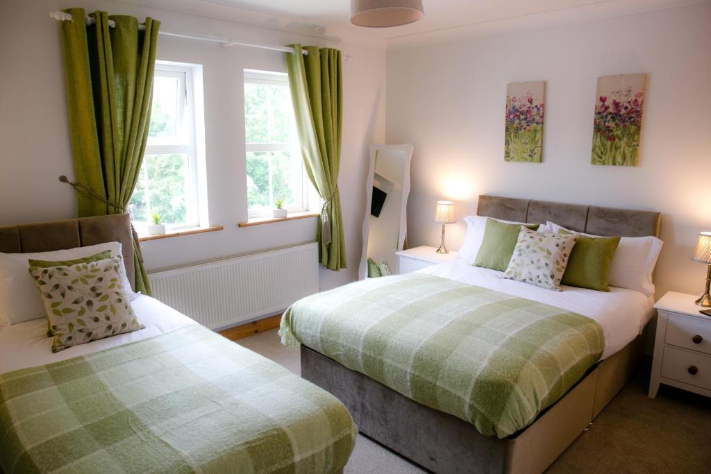 1 dormitorio con 2 camas y 2 ventanas en Farmleigh House, en Donegal