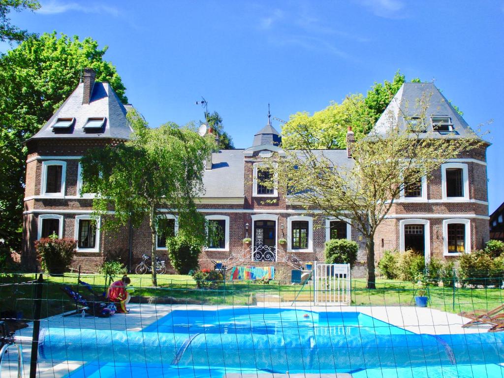 ein großes Haus mit Pool davor in der Unterkunft Chateau de la Vallee - East or West Wing (each wing self-contained with own entrance) in Grandcourt