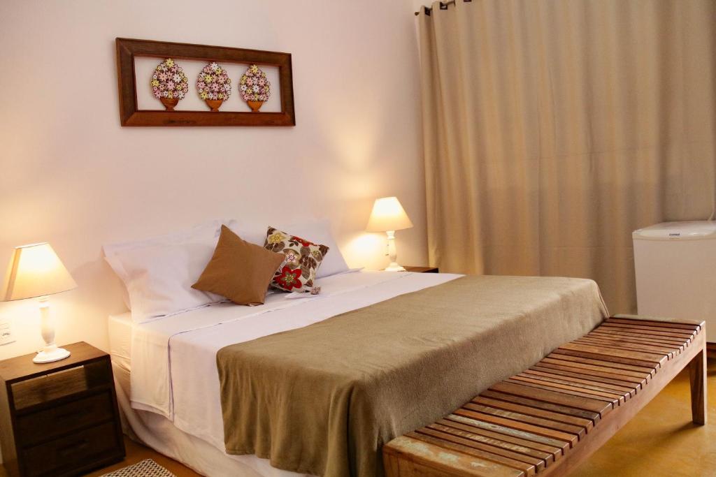 ein Schlafzimmer mit einem Bett und einer Bank darin in der Unterkunft Pousada Berço Mineiro in Tiradentes