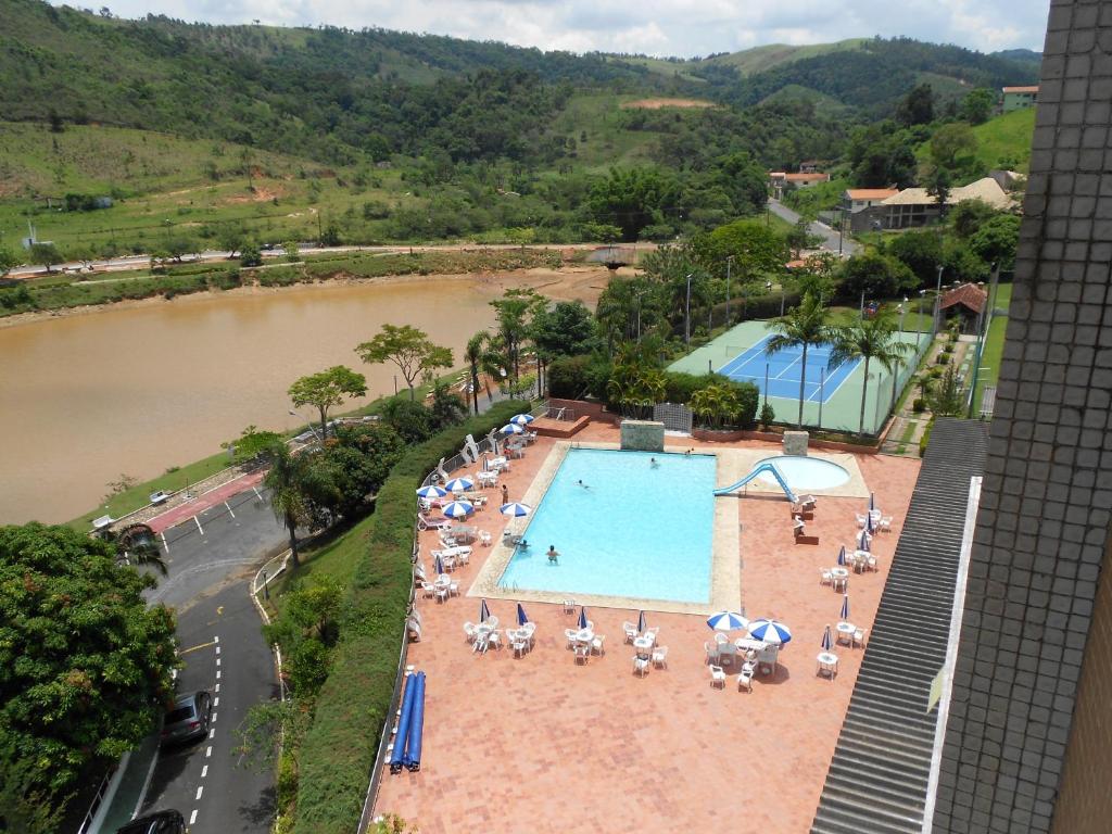 an overhead view of a pool with chairs and umbrellas at Flat no Hotel Cavalinho Branco in Águas de Lindóia