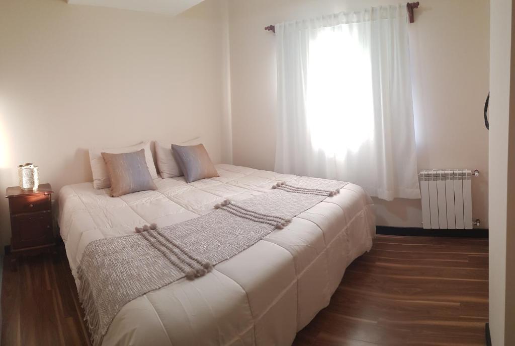 a bedroom with a large white bed with a window at Departamento zona céntrica (Caseros) in Salta