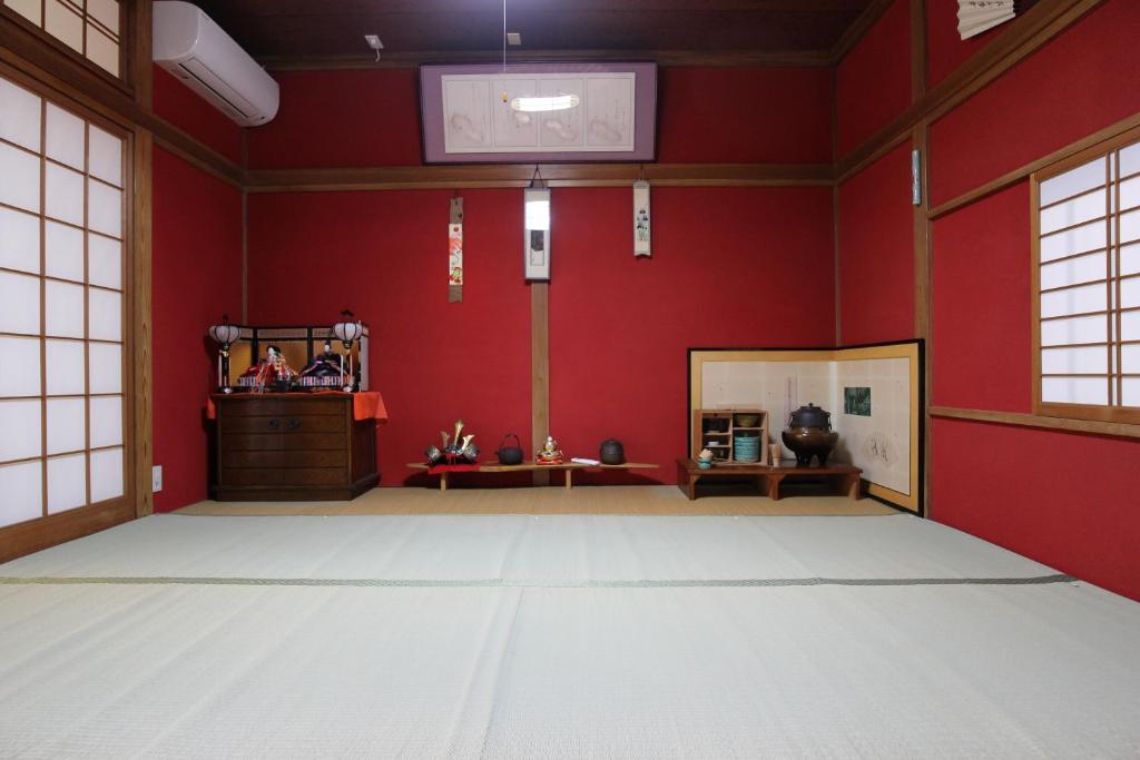 an empty room with red walls and a mirror at Maidohaya Fukutatei in Takaoka
