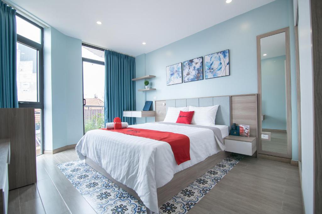 una camera da letto con un grande letto con cuscini rossi di Soleil Apartment a Hanoi