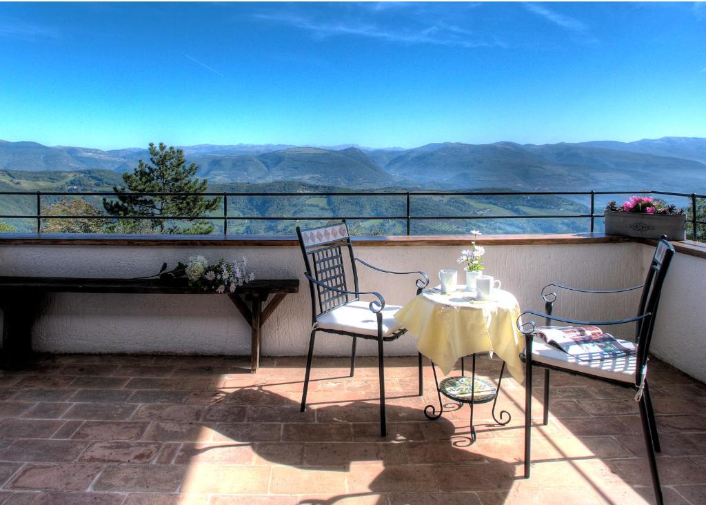 Casa Vacanze Assisi في سبيلّو: طاولة وكراسي على شرفة مطلة