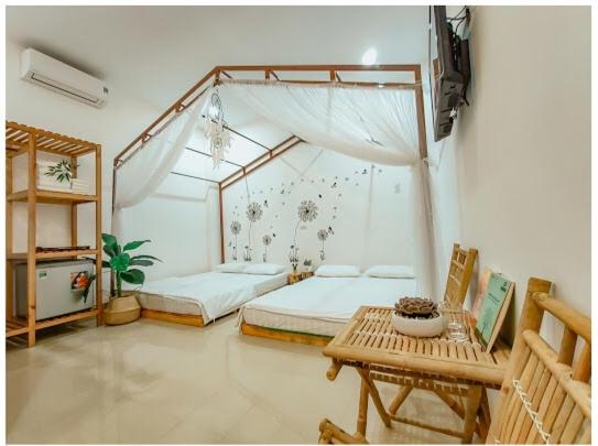 a bedroom with two beds and a table in it at Mây Homestay in Liên Trì (3)