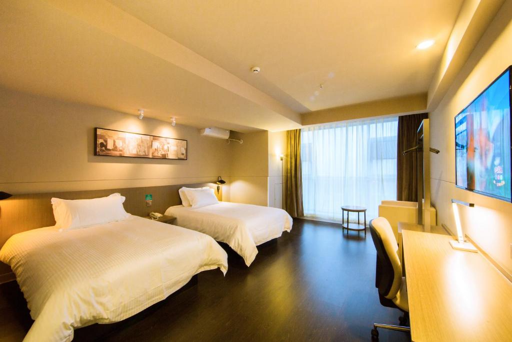 A bed or beds in a room at Jinjiang Inn Select Kunming South Railway Station University Town