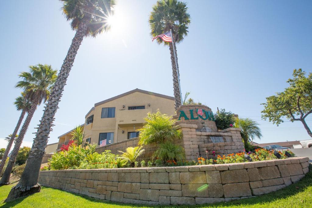 a monument in front of a building with palm trees at Aloha Inn in Arroyo Grande