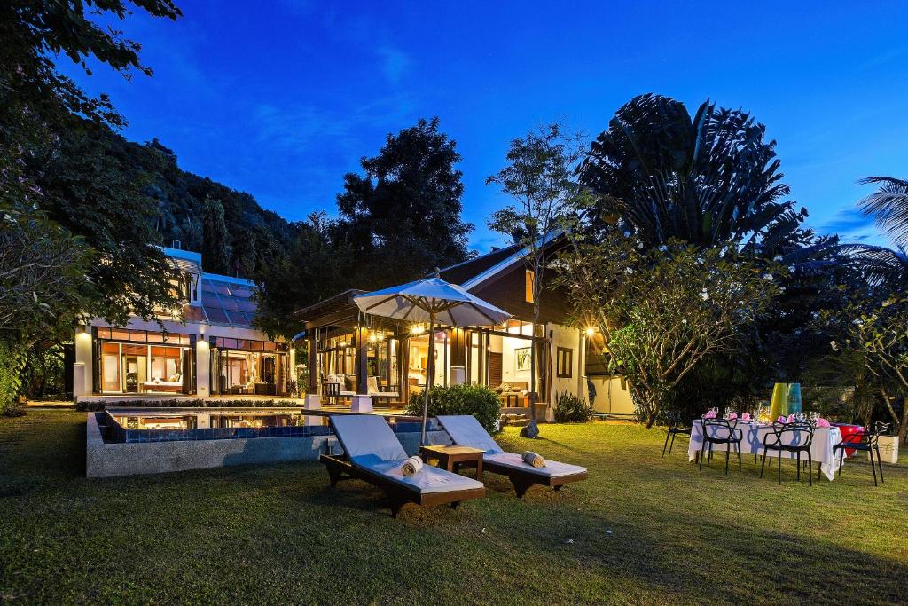 a house with a backyard with a pool and a table at The Emerald Hill Beach Villa in Mae Nam