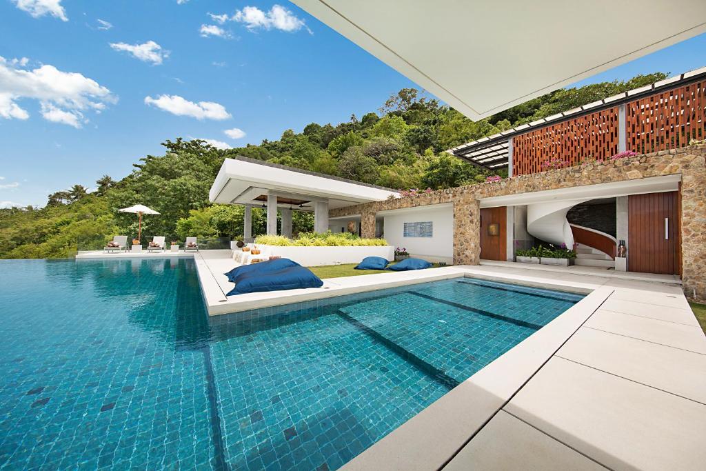 an infinity pool in the backyard of a house at Villa Blue View in Mae Nam